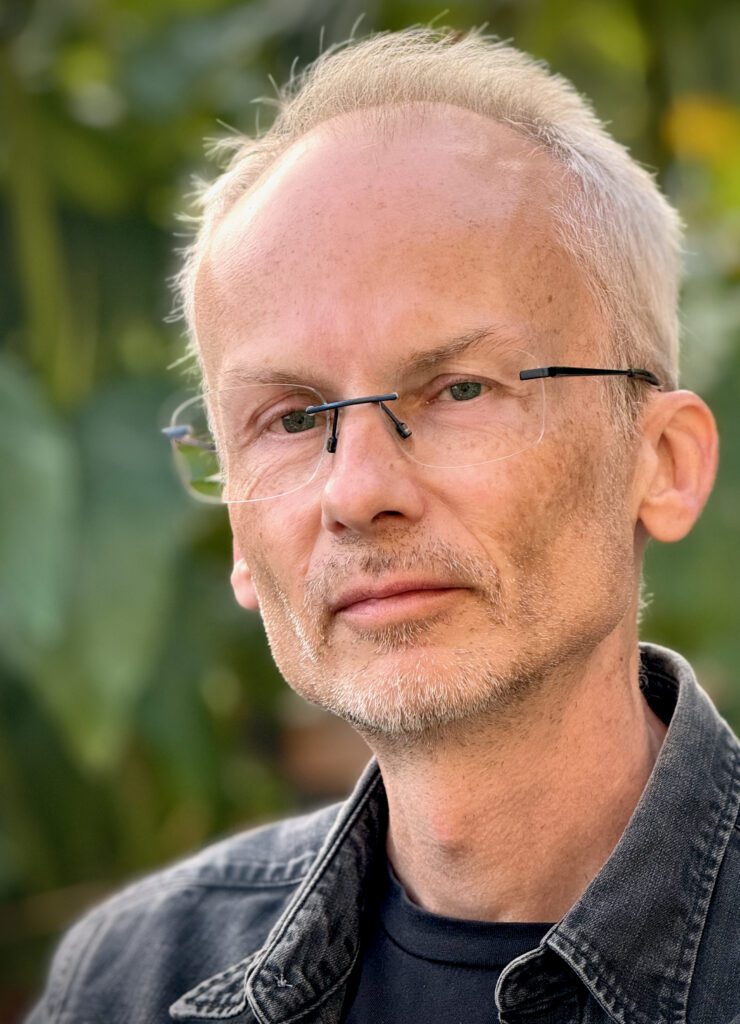 Porträtt på filosofiske praktikern Mathias Tistelgren. Han ses i närbild men en grön bakgrund.